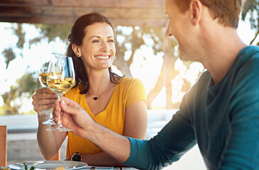 Date, wine and couple with cheers on patio for celebration, lunch and romance in happy relationship. Smile, man and woman toast with glass, drinks and outdoor dinner with love, bonding and marriage.