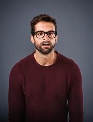 Fototapeta premium Studio, glasses and man with funny face, eye care and wellness with frame, portrait and lens for vision. Gray background, healthy and product for person, prescription and eyewear with fashion in USA