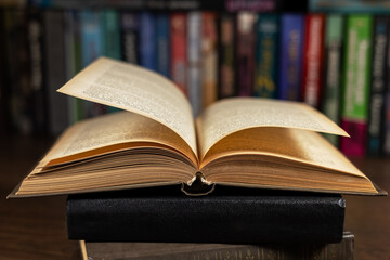 opened book, lying on the bookshelf in library