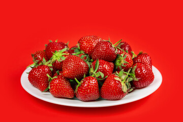 Ripe red strawberries on red background