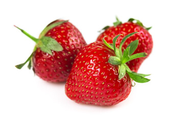 Three strawberries with strawberry leaf on white background
