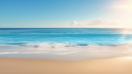 Fototapeta premium Motion blurred ocean waves washing sandy beach. Gentle waves washing onto a sandy beach under a clear blue sky and bright sunlight.
