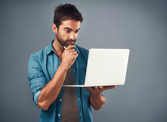 Thinking, businessman and laptop for research or brainstorming with vision or ideas in studio. Thoughts, male person or employee and computer for learning or internet, email with gray background