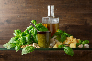 Pesto sauce and ingredients on a old wooden background.