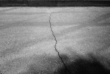 Crack on the road with glass reflections on it backdrop