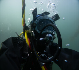 Commercial diver in helmet working underwater