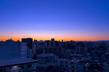 夕焼けの街遠くの富士山