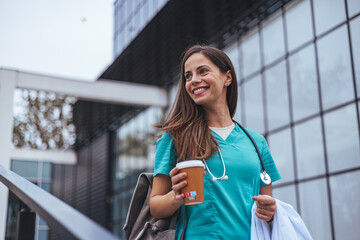 A cheerful Caucasian female nurse, clad in scrubs with a stethoscope, relishes a break while...