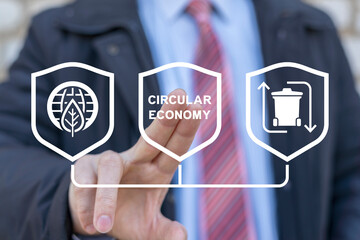 Business man using virtual touch screen presses text: CIRCULAR ECONOMY. Concept of circular economy...