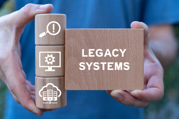 Man holding wooden blocks sees inscription: LEGACY SYSTEMS. Legacy System Business Technology...
