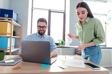 Photo of happy busy coworkers wear shirts communicating modern device indoors workplace workstation