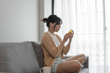 Asian woman Search for information on Internet in smartphone with holding bottled drug. girl...