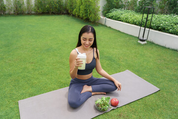 Sporty asian woman in sportswear drinking protein shake from bottle After Exercise for Energy...