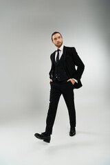 Bearded businessman exudes confidence in stylish suit and tie against a neutral background.