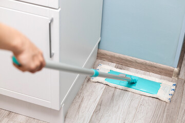 housewife wiping the floor with a dry mop