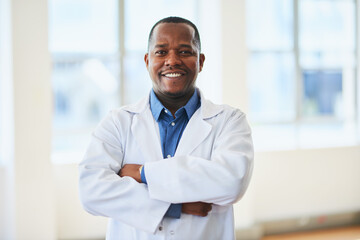 Confident Male Doctor Posing in White Coat in Modern Hospital