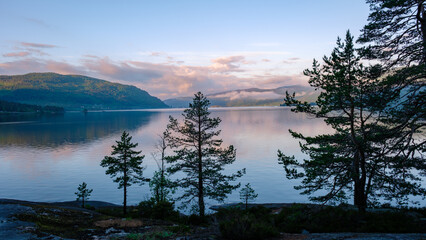 Byglandsfjord Lake with trees in Norway is, a beautiful mountain lake at sunrise