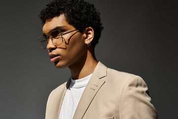 Handsome young man in glasses and tan suit, exuding elegance and sophistication.