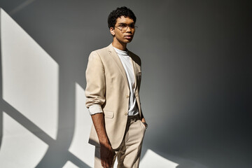 Handsome African American man in tan suit and sunglasses striking a confident pose