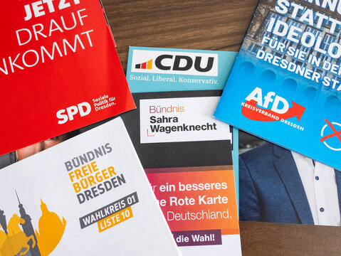 DRESDEN, GERMANY - 31. May 2024: Political flyers for the municipal election. Different German parties like the CDU, SPD, AfD, BSW lying on the table. Mailbox advertisement to win more voters.