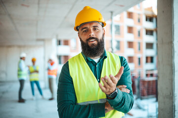 A cheerful male worker with a beard dons safety gear while engaging in work at a bustling...