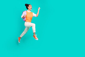 Full size photo of nice young girl jump run empty space wear vest isolated on teal color background
