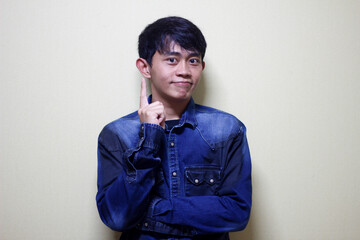 Young Man with Index Finger Up Expressing an Idea or Question