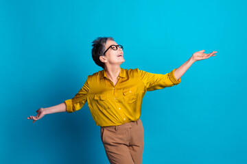 Photo of confident attractive lady dressed shirt glasses dancing emtpy space isolated blue color...
