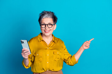 Photo of adorable good mood lady dressed shirt eyewear texting modern gadget pointing empty space...