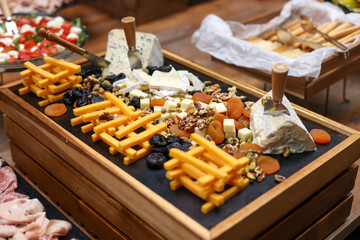 Shallow depth of field (selective focus) details with various types of cheese at a buffet.