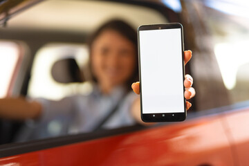 Woman sitting in car and holding phone. Close up of phone in hand, focus on phone