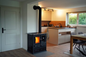 Cozy living room with a retro fired stove and a modern kitchen in the background