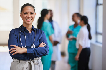 Confident Female Doctor Leading a Diverse Medical Team in a Hospital Corridor