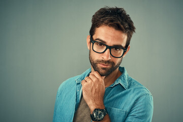 Portrait, thinking and man with ideas, glasses and problem solving on grey studio background. Face,...
