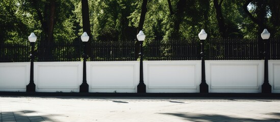 White concrete pillars with a black chain fence surround the object in the park, creating a protective perimeter with a copy space image.