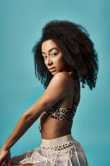 Young African American woman striking a pose in a leopard skirt on a vibrant blue background.