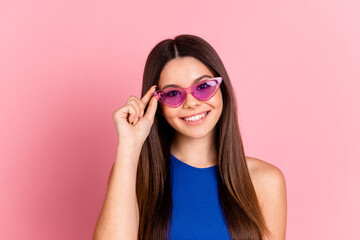 Photo of charming positive girl wear blue top arm dark glasses empty space isolated pink color...