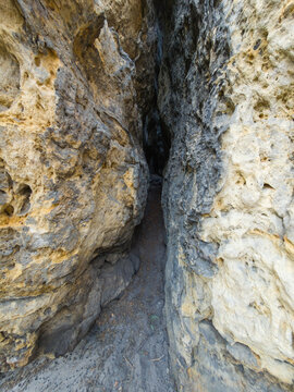 Narrow rock crevice between sandstone walls at the Pust&yacute; z&aacute;mek rock castle, Kokoř&iacute;nsko, Czechia