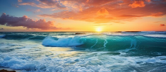 Beautiful turquoise waves in the ocean off the coast of Cozumel with a stunning sunset in the background in this copy space image.