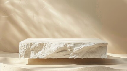 A smooth, rectangular marble block rests on sand with sunlight casting dynamic, rippling shadows across its surface.