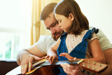Father, home and child with guitar on sofa, learning music and family bonding or teaching...