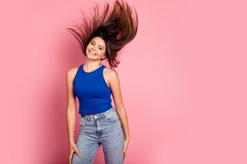 Photo of adorable lovely girl wear tank top flying hair empty space isolated pink color background
