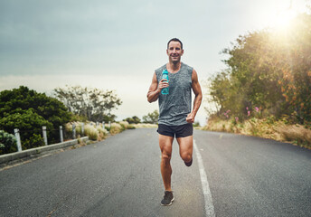 Running, happy man and portrait with water bottle for exercise, cardio and fitness on road in...