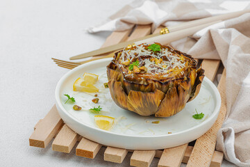 Delicious baked artichoke with parmesan cheese and pistachio. Olive oil, garlic, parsley and lemon