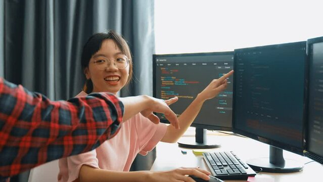 Slow motion back end software developer engineer for computer programming working together on debugging writing computing code, solving complex algorithms display on monitor in office. Burgeoning
