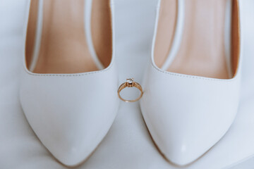 A white shoe with a diamond ring on it