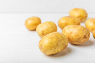 Young potatoes. Fresh potatoes  on a wooden background.Harvesting collection. organic, freshly dug potatoes. Agricultural background. Vegan. Vegetables.Place for text.Copy space