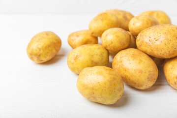 Young potatoes. Fresh potatoes  on a wooden background.Harvesting collection. organic, freshly dug potatoes. Agricultural background. Vegan. Vegetables.Place for text.Copy space