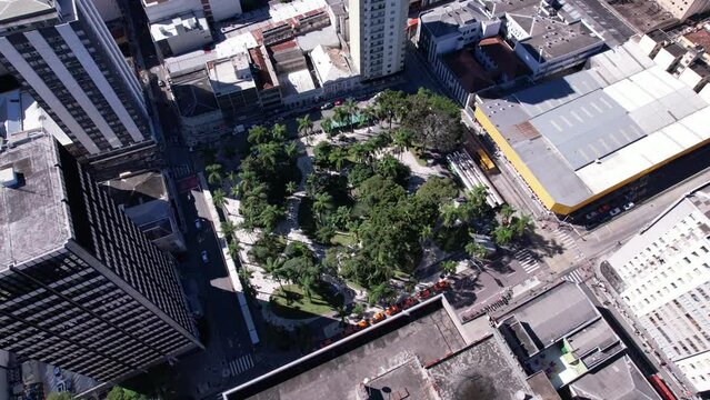 V&iacute;deo de drone da pra&ccedil;a os&oacute;rio em Curitiba. Paisagem urbana do centro da cidade se mistura a natureza das &aacute;rvores