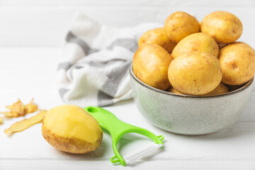 Young potatoes. Raw potatoes and knife on a wooden background.Peel potatoes.Harvesting collection. organic, freshly dug potatoes. Agricultural background. Vegan. Vegetables.Place for text.Copy space